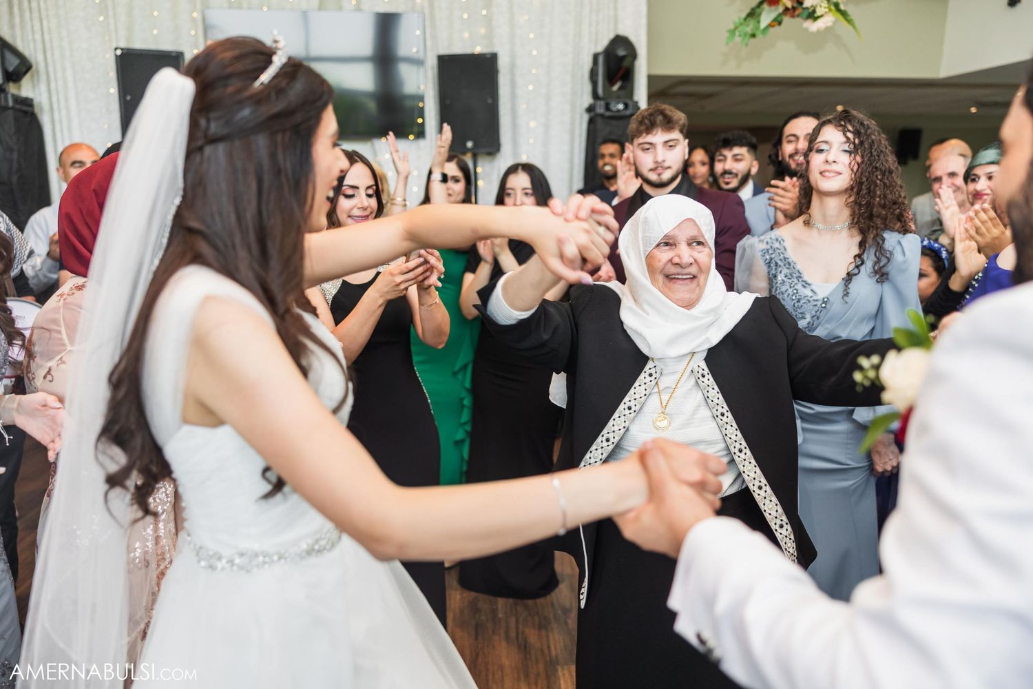 Wedding celebration with guests dancing in circle during reception.