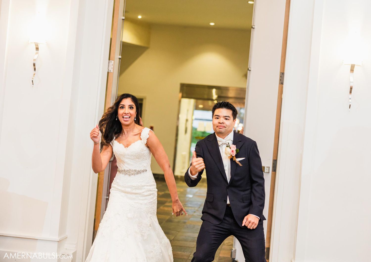 Couple makes a grand entrance through white doors at their wedding reception.