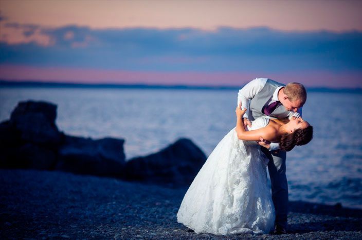 Romantic sunset beach wedding photos with dramatic coastal cliffs in the background.