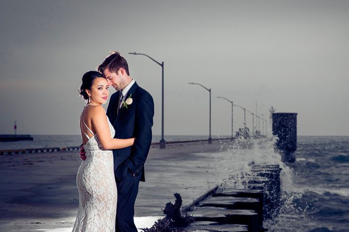 Romantic coastal wedding photos with pier and ocean horizon in background.