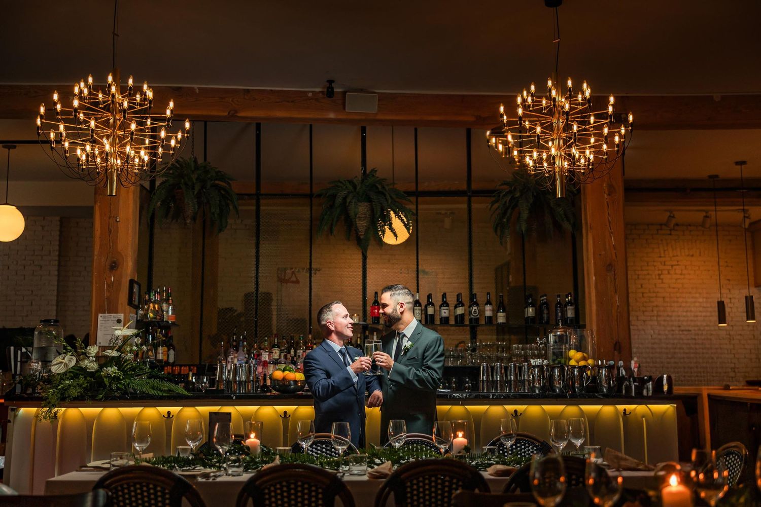 Elegant reception venue with hanging chandeliers and romantic ambient lighting.