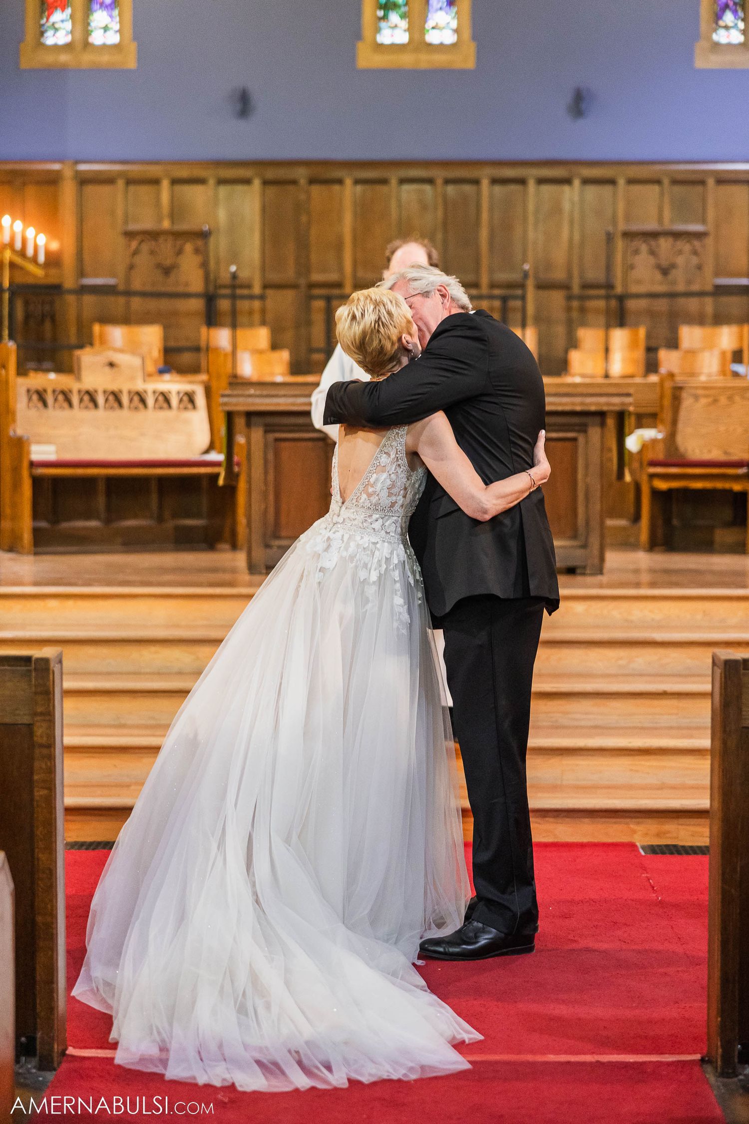 Couple embracing during emotional moment at church wedding ceremony.