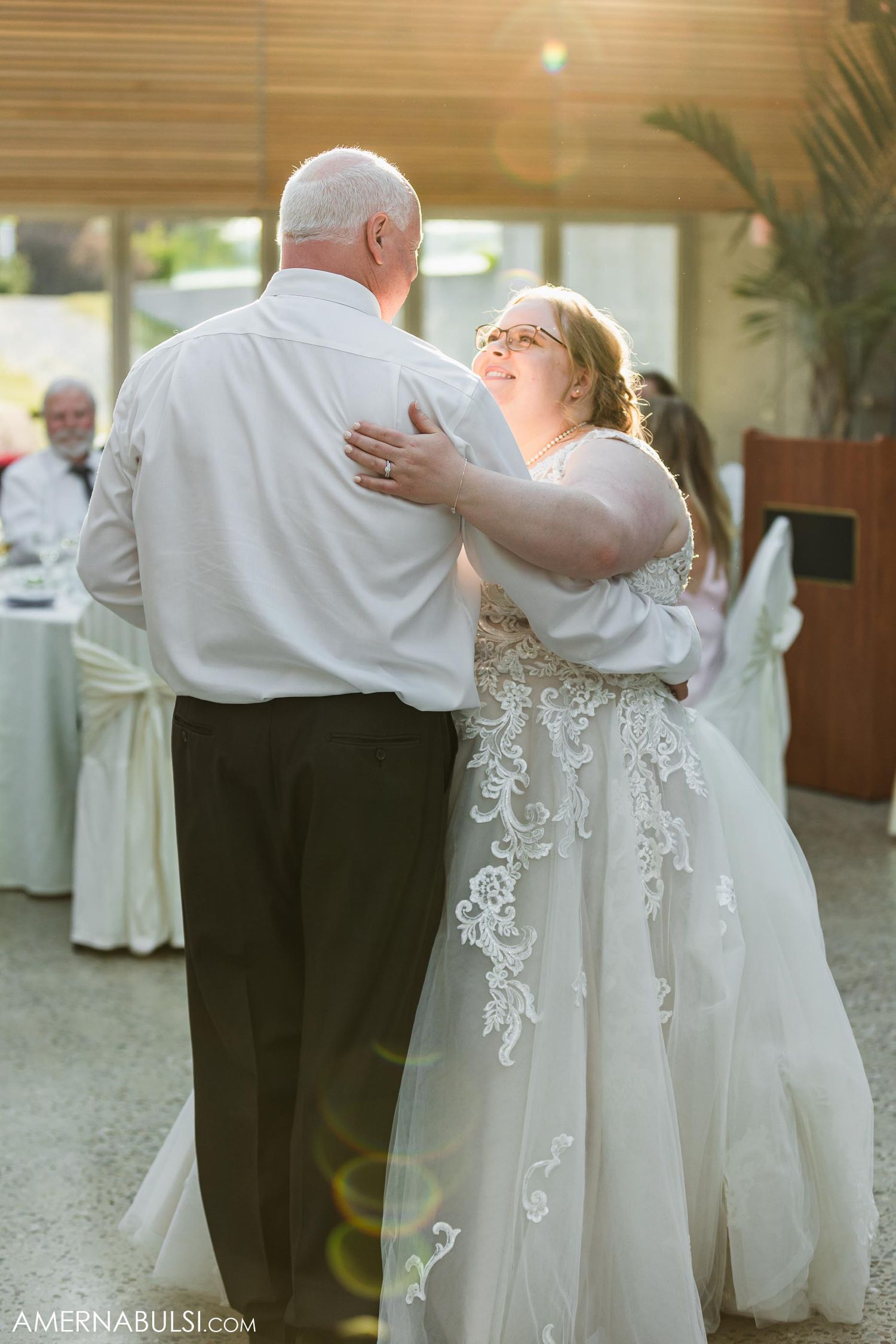 A couple embraces during a romantic slow dance at their wedding reception.