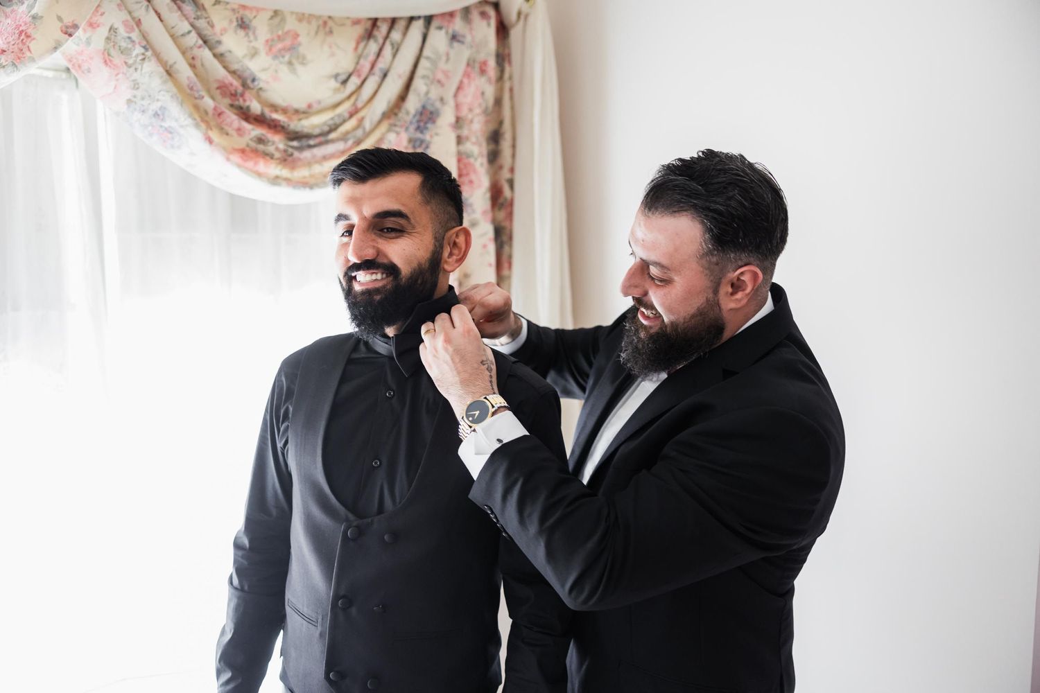 Wedding preparation scene showing final adjustments to formal attire.