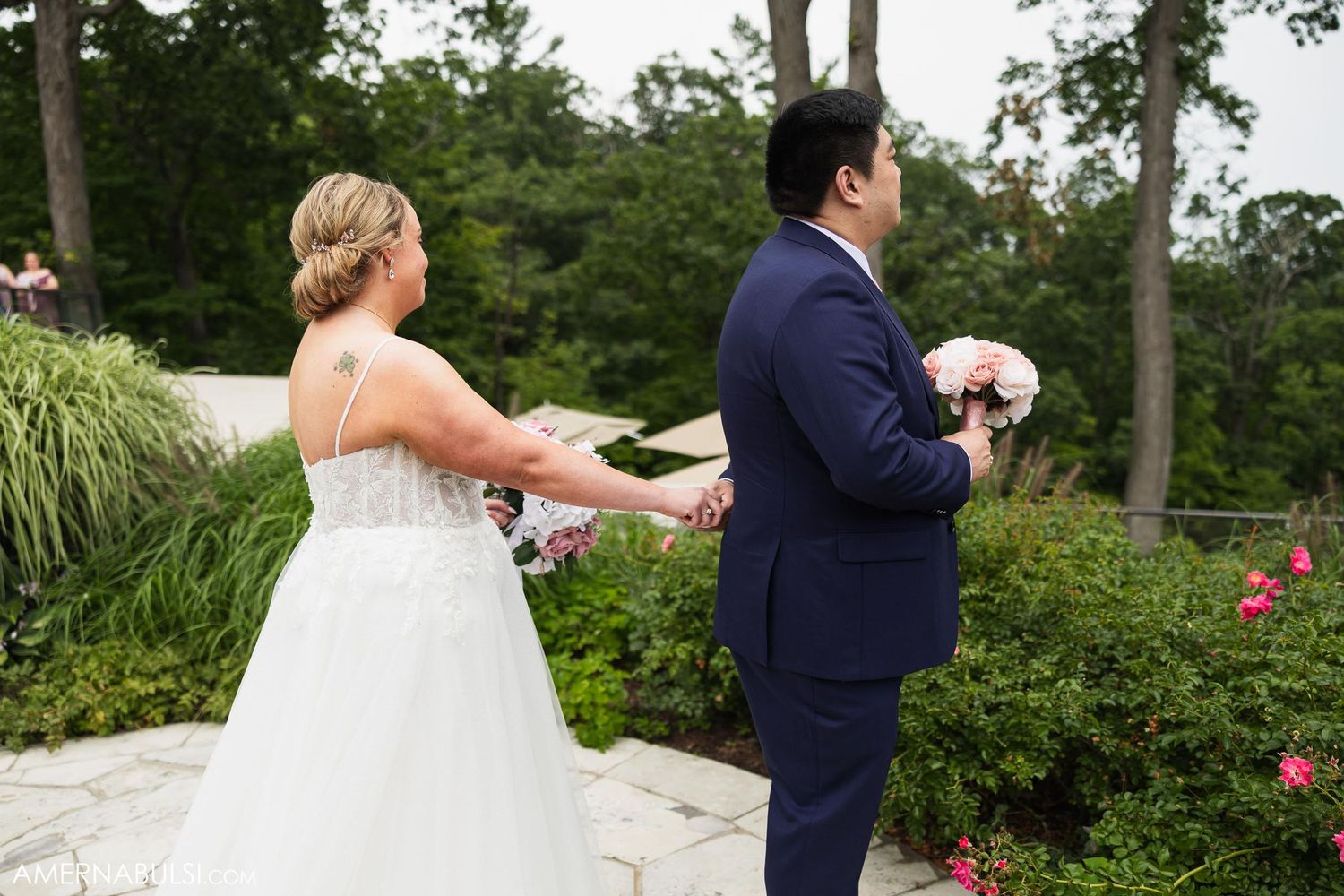 Candid moment between couple during first look in garden setting.