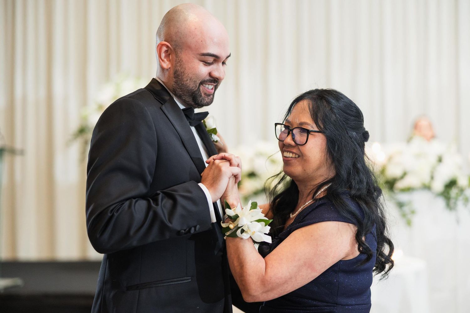 A couple shares a joyful dance moment at their wedding reception.