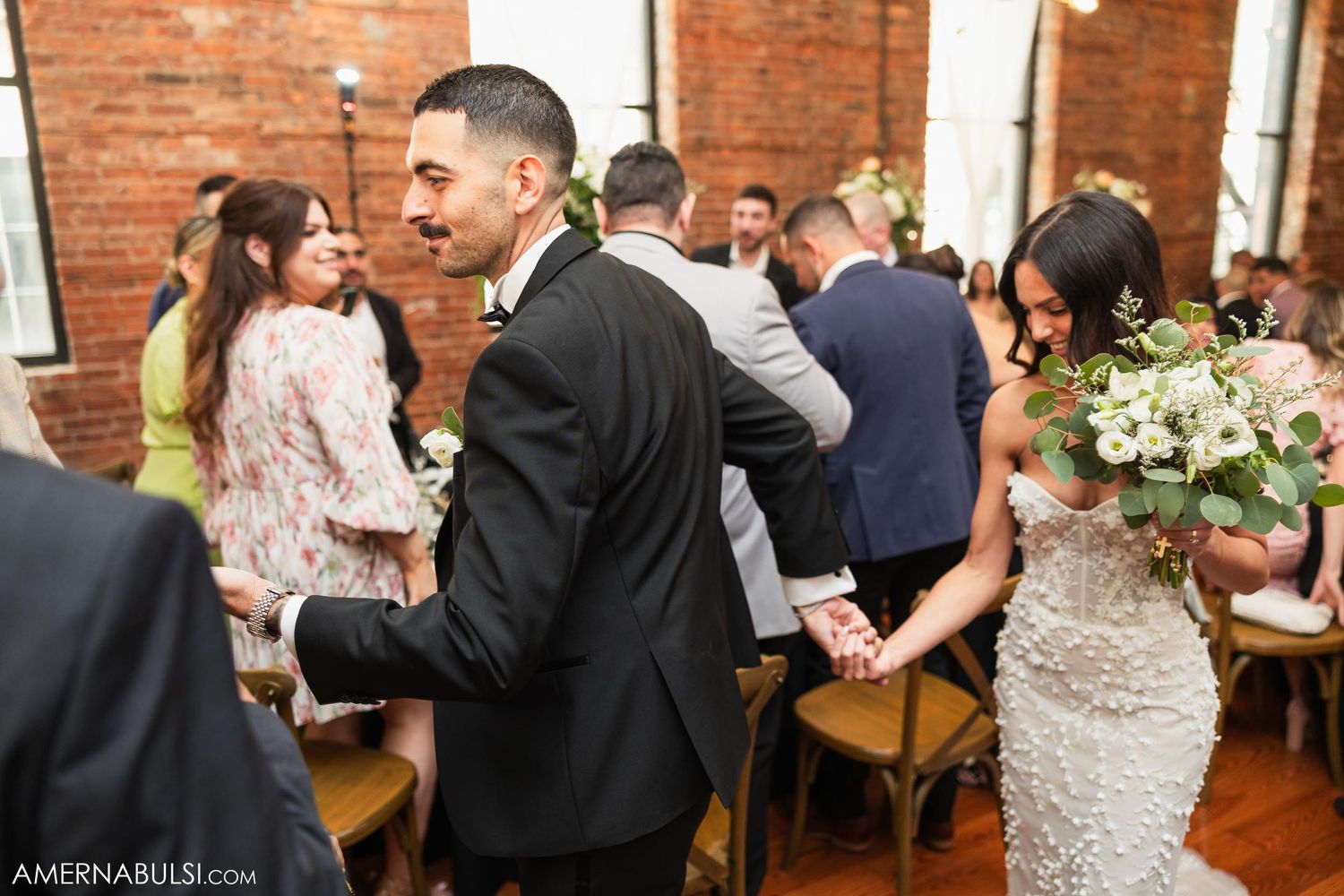 Wedding reception in a rustic venue with exposed brick walls and elegant table settings.