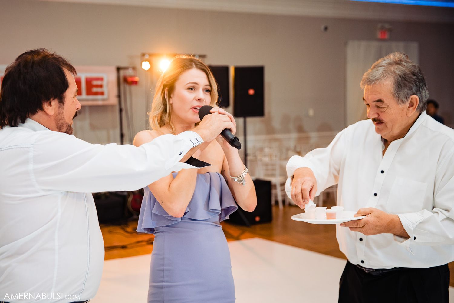 Dance instructors demonstrating steps during a group dance lesson in a bright studio space.