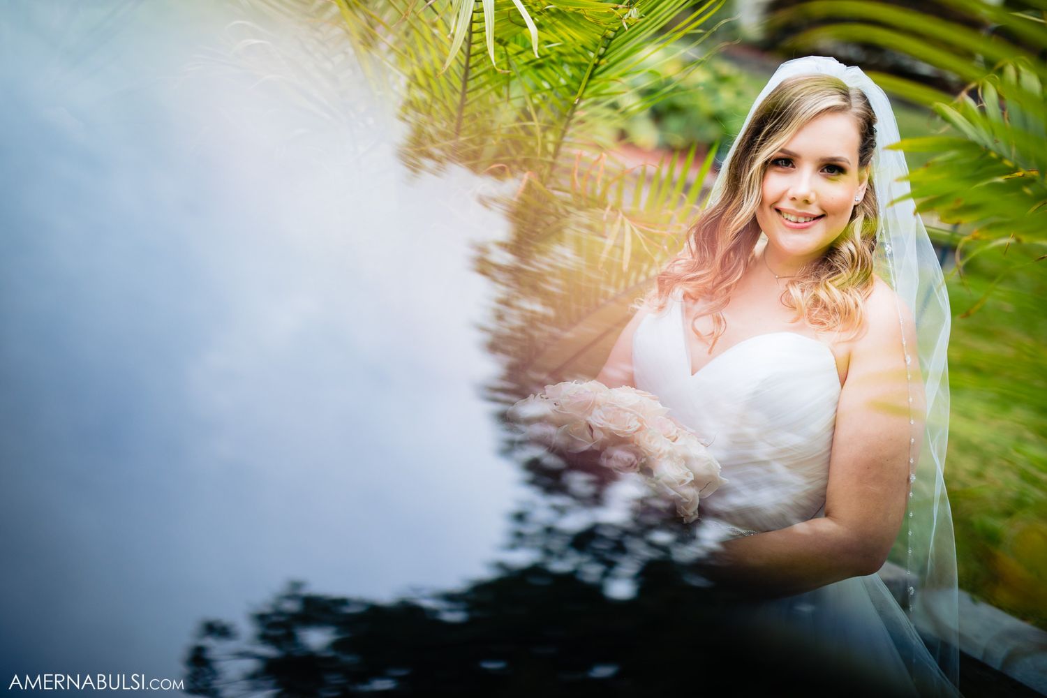 Artistic wedding photography through tropical foliage creating dreamy natural light effects.