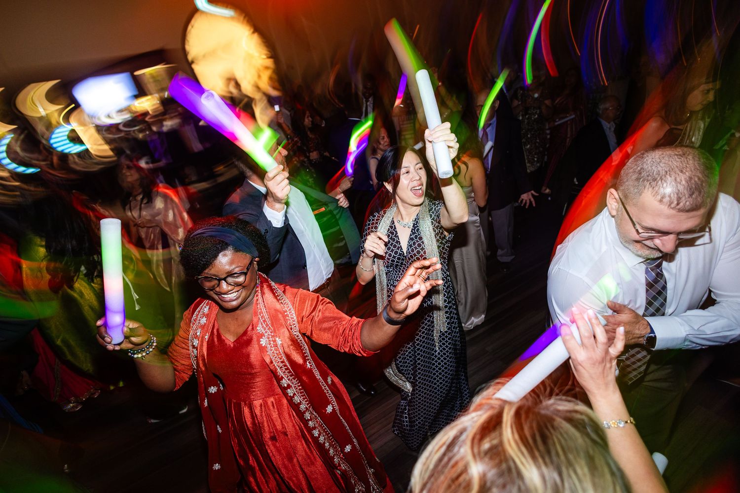 Dance party scene with glowing lights and energetic crowd in motion.