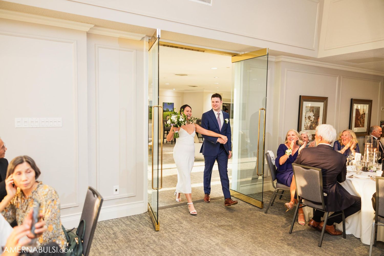 Newlyweds make their grand entrance into the wedding reception ballroom.