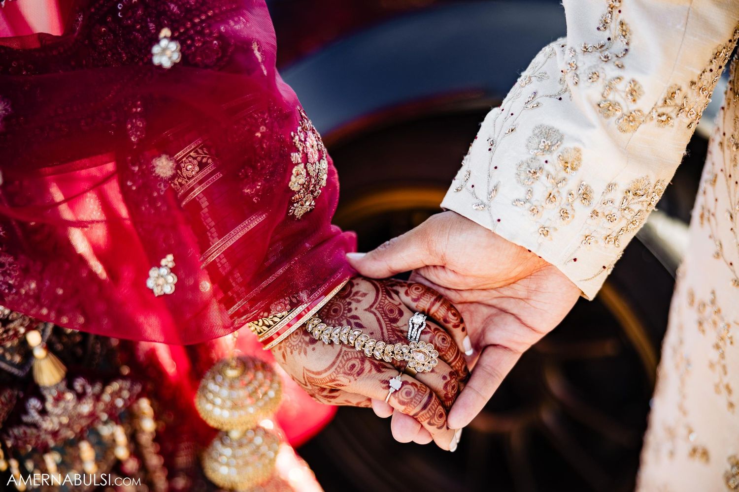 Close-up of hands with intricate henna designs during a traditional wedding ceremony.
