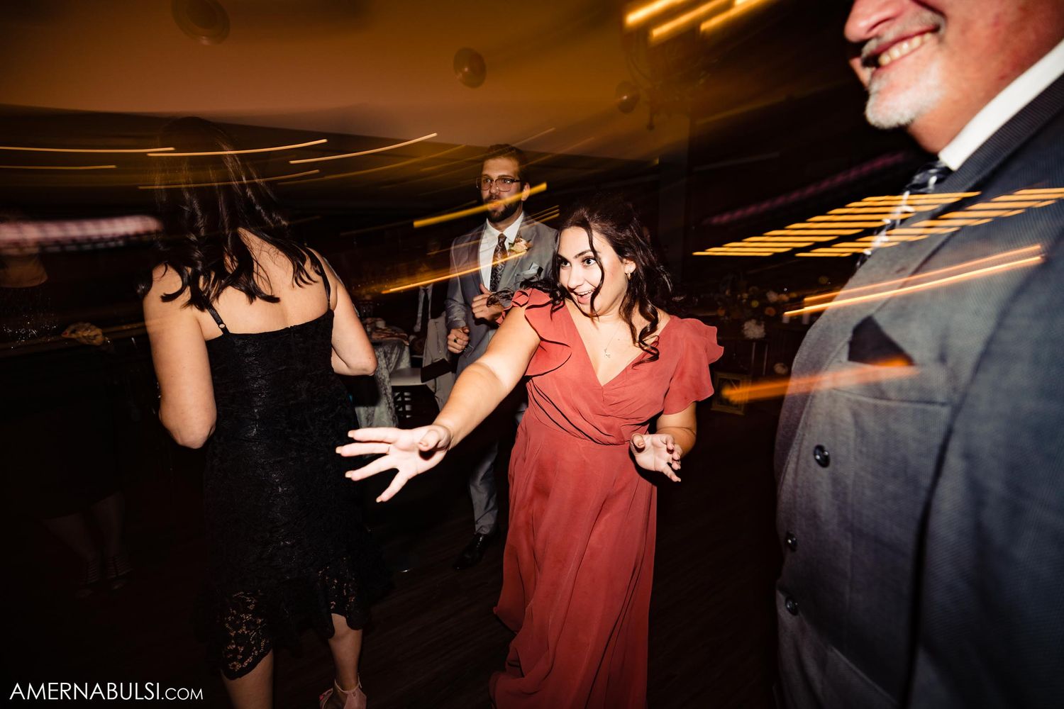 Wedding guests dancing and celebrating on the dance floor.