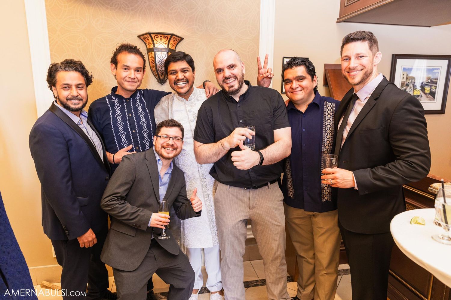 Group of groomsmen pose together for casual photo at wedding reception.