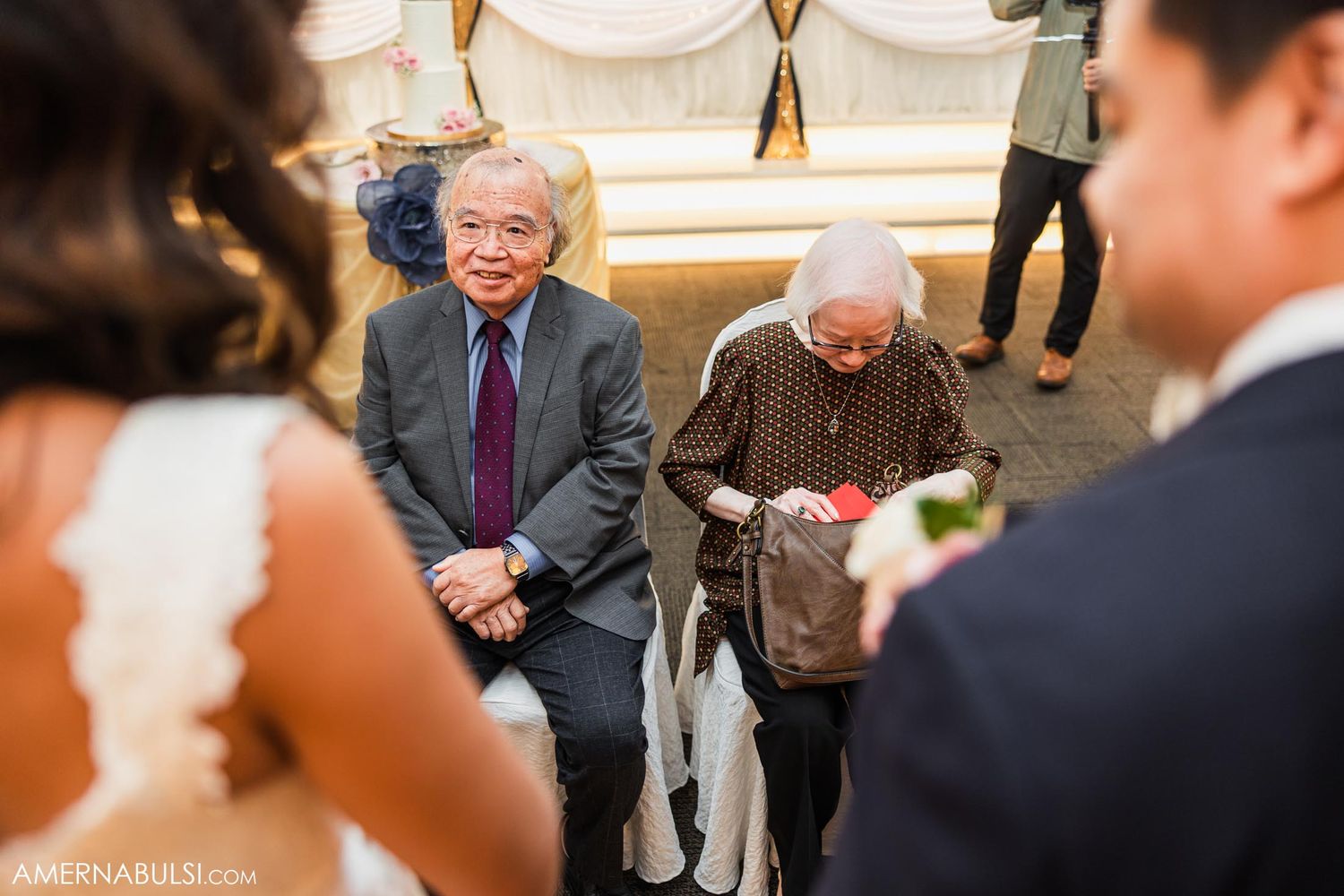 Elderly guests seated during wedding celebration in formal attire.