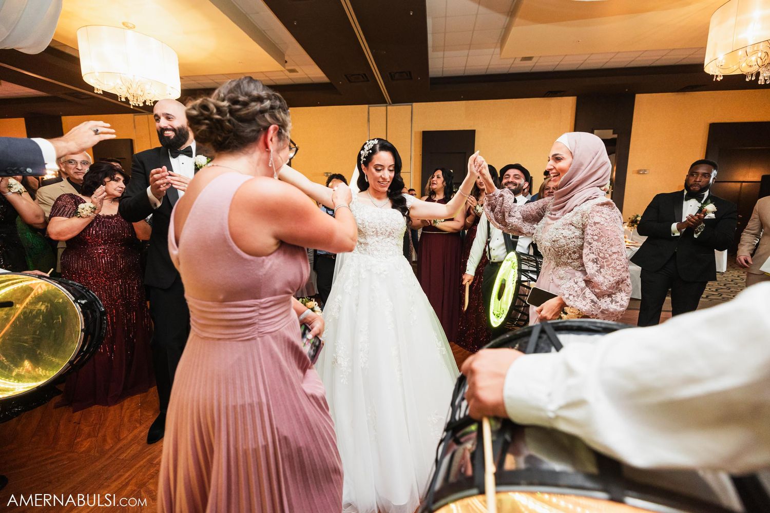 Wedding guests dancing and celebrating at reception with live band performance.