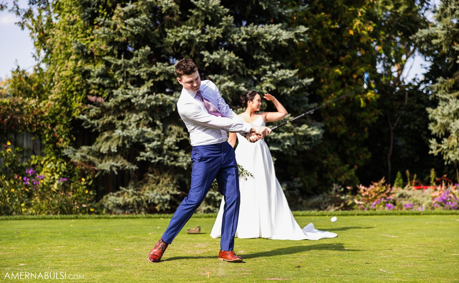 A playful dancing moment between newlyweds on manicured garden grounds.