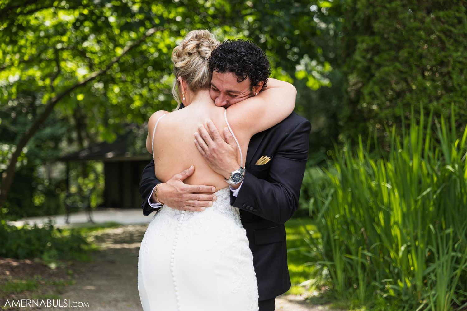 Intimate embrace between couple during garden wedding photoshoot.