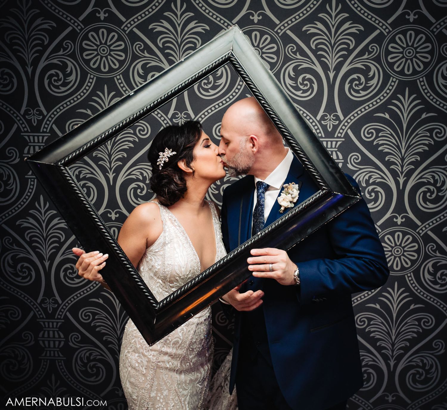 Artistic black and white wedding portraits against an ornate damask wallpaper background.