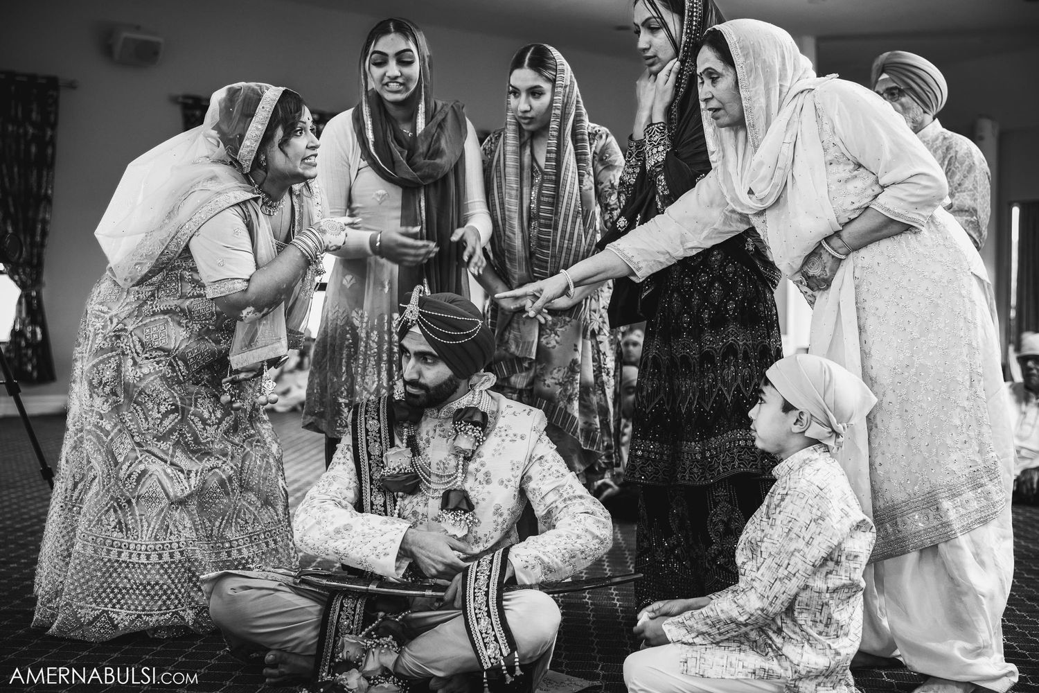 Black and white photo of a traditional Sikh wedding ceremony with participants gathered in a circle.