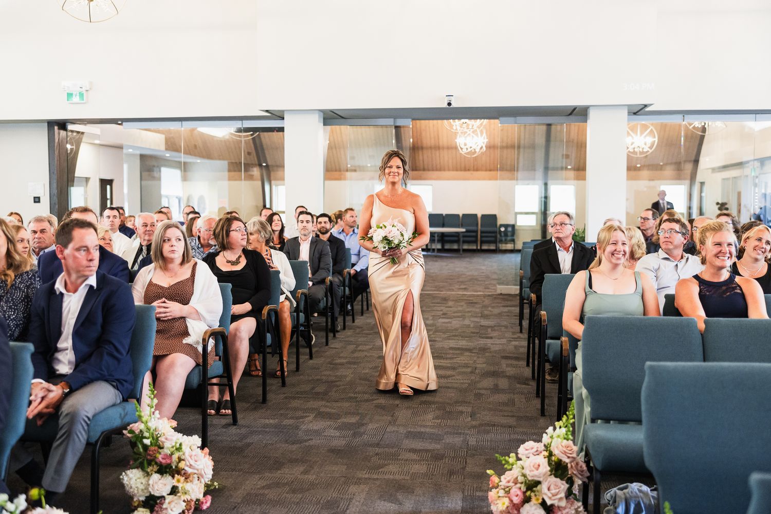 Wedding ceremony venue with guests seated in rows and floral-lined aisle.