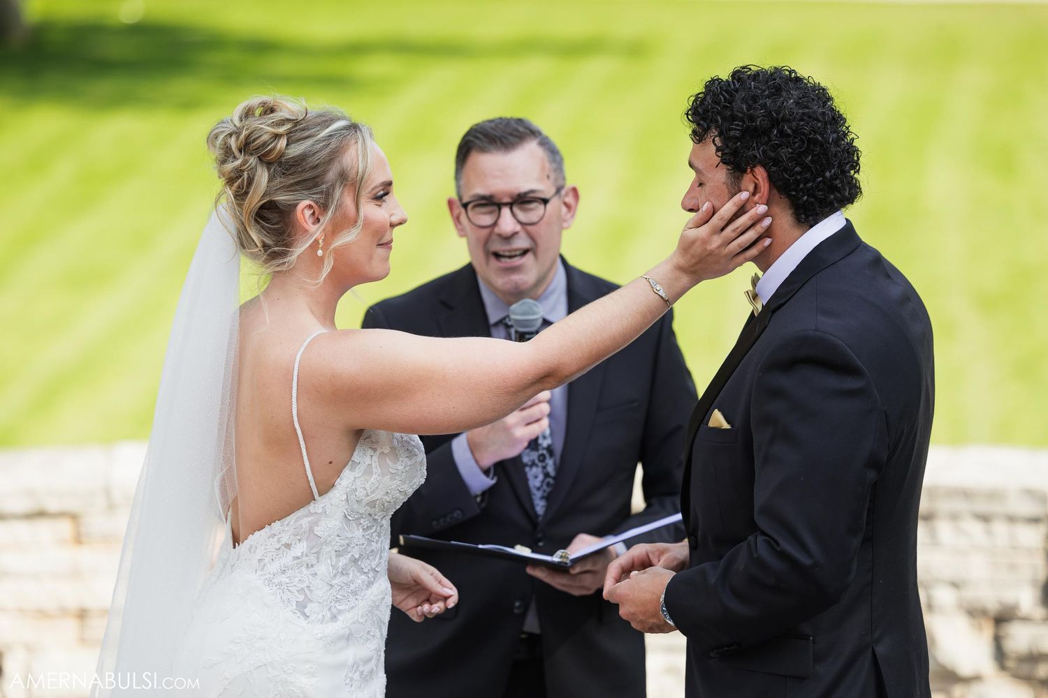 Emotional moment during outdoor wedding ceremony as couple exchanges vows.