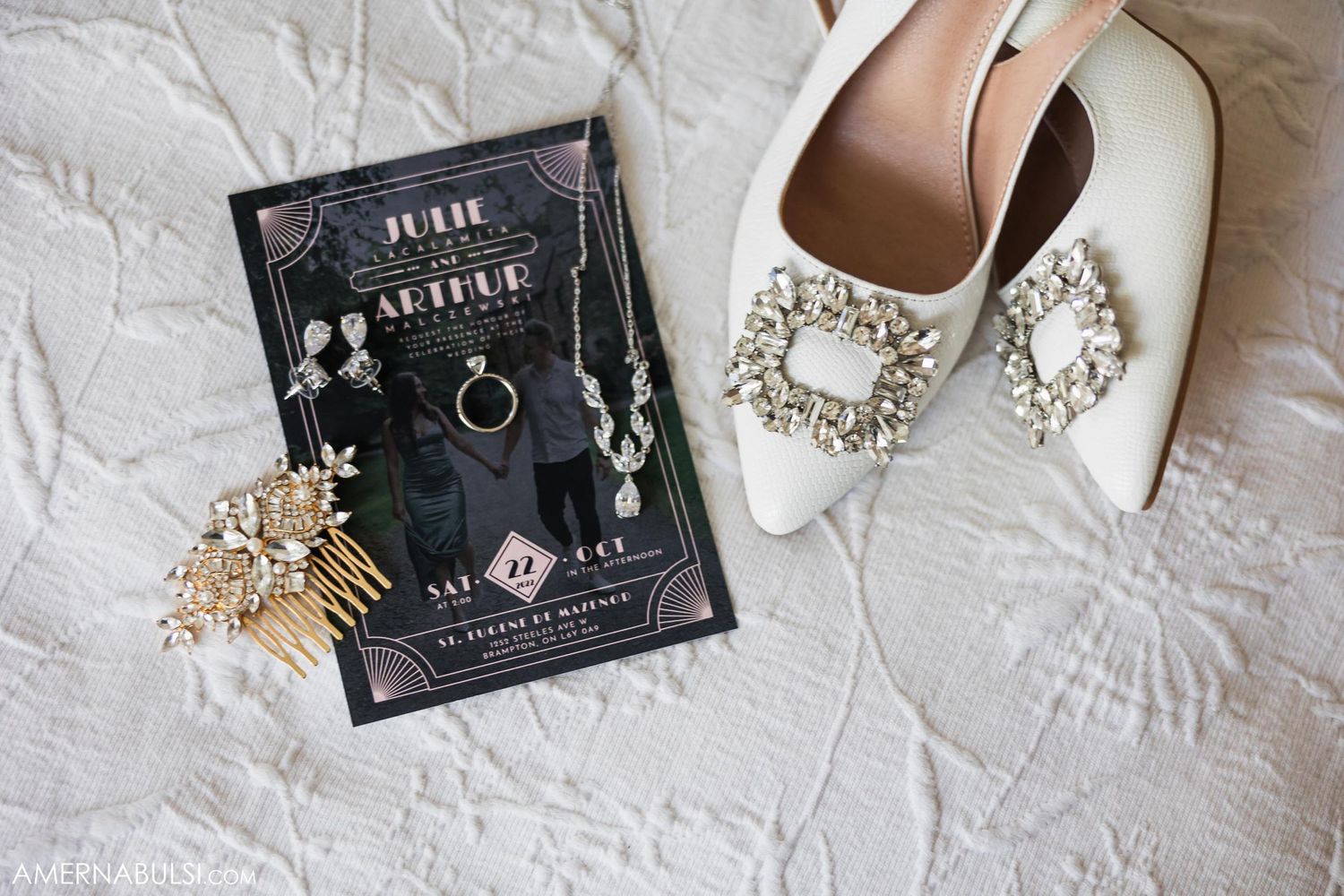 Wedding accessories including ornate shoes and invitation on white textured surface.