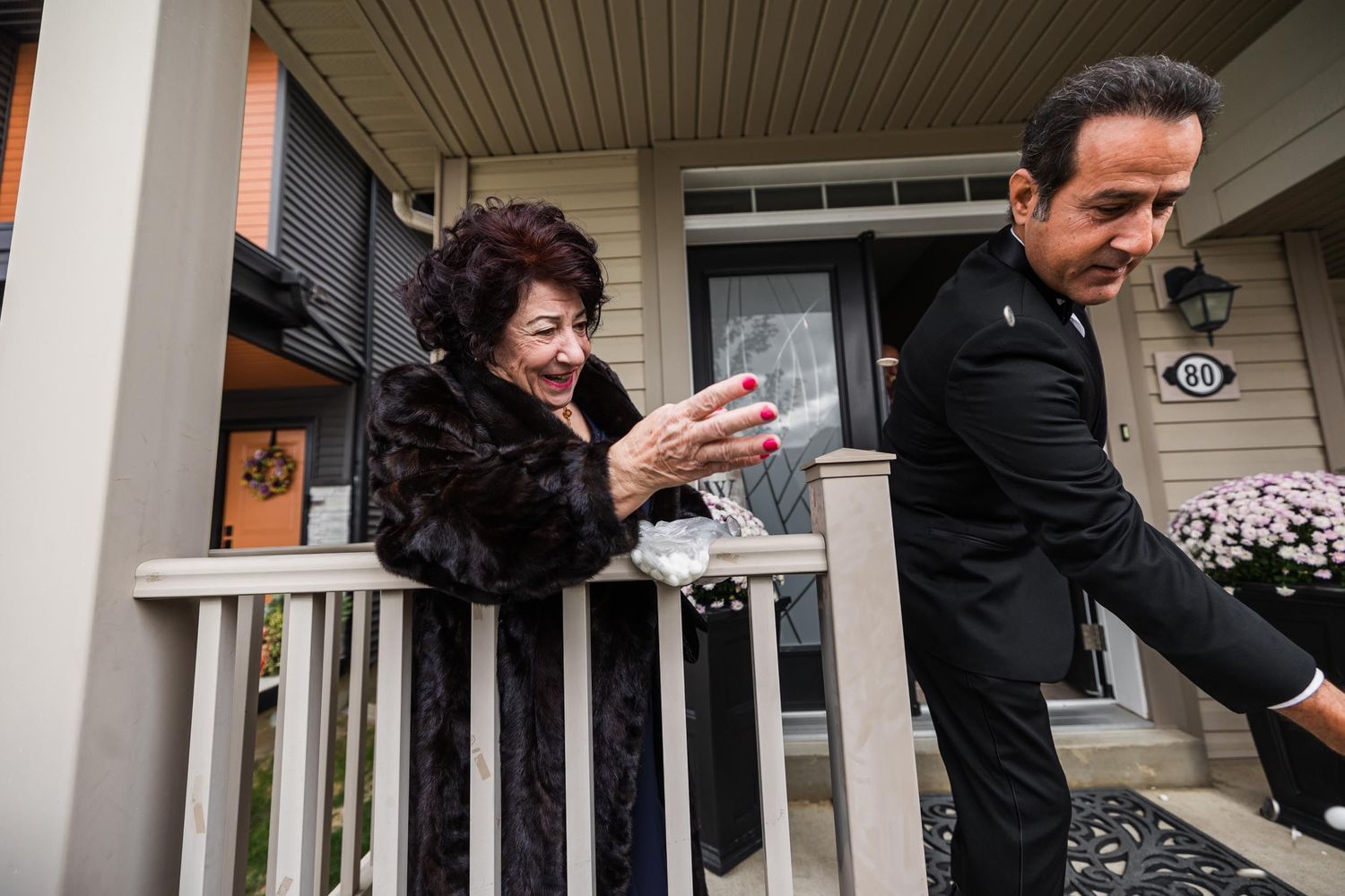 Expressive reactions outside on a front porch during a wedding event.