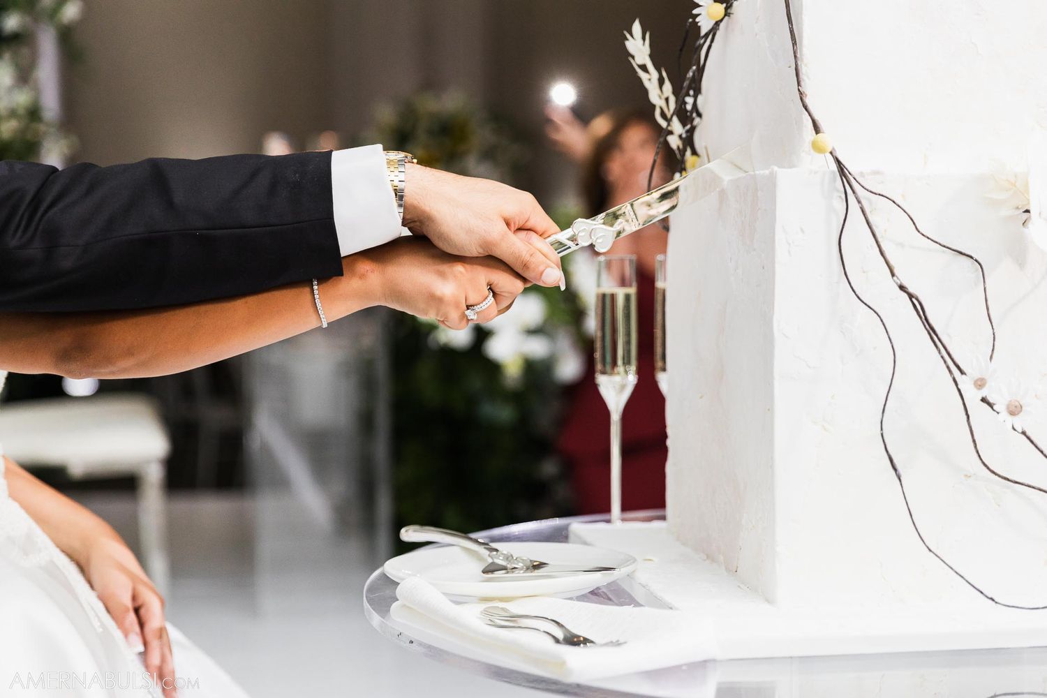 Close-up of hands pouring champagne at an elegant wedding reception.