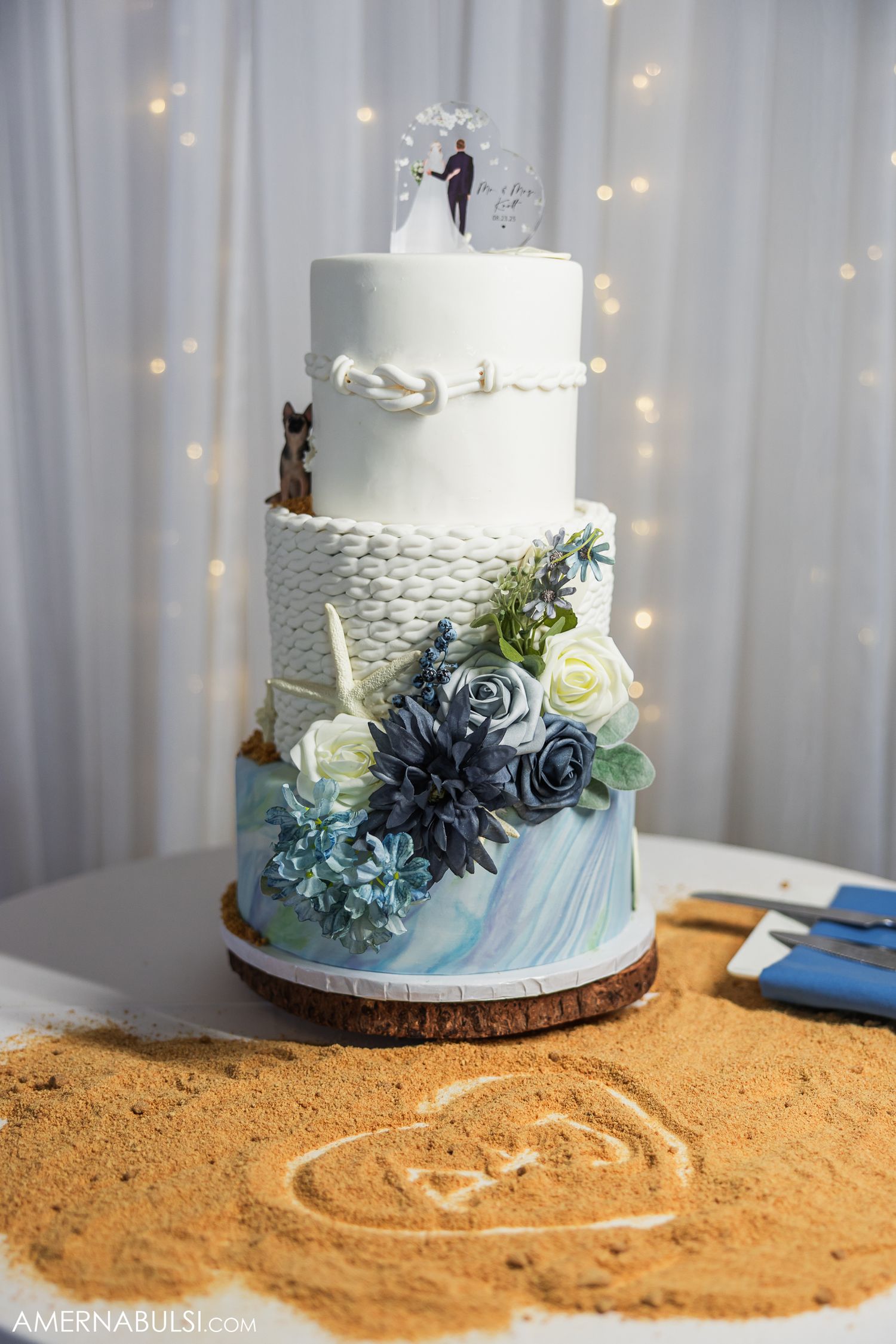Three images of a beach-themed wedding cake with blue fondant waves and brown sugar sand detail displayed against twinkle lights.