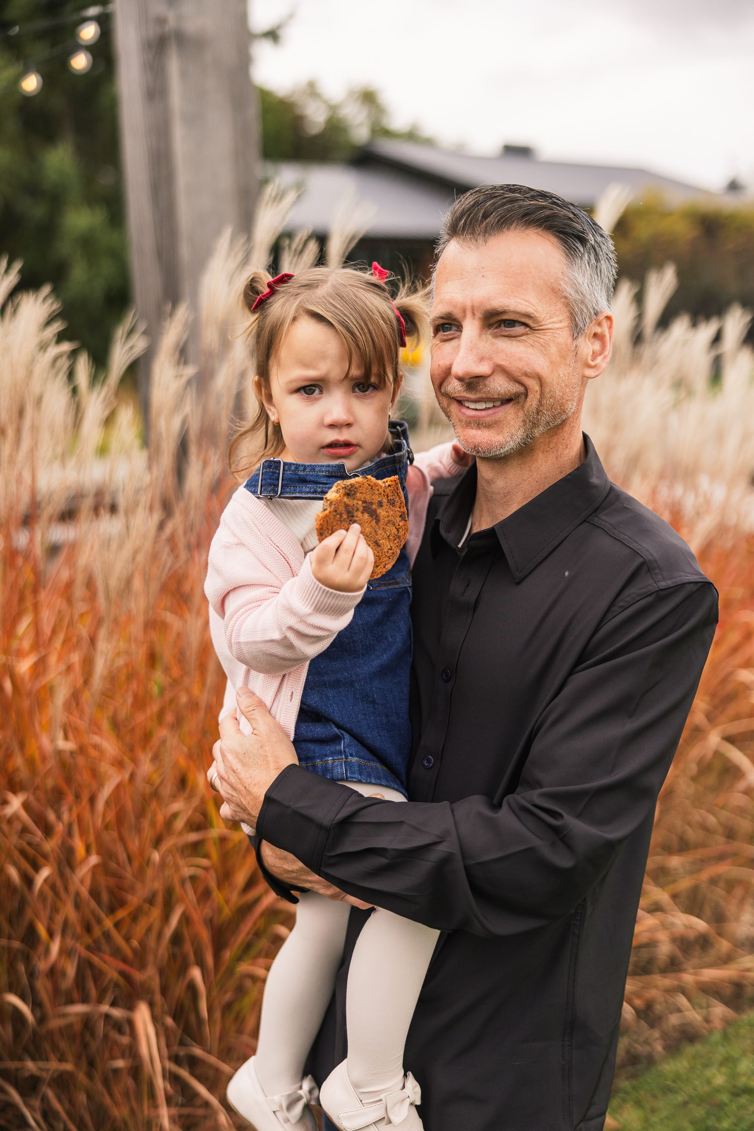A heartwarming series of candid moments between a parent and child playing outdoors in autumn grasses.