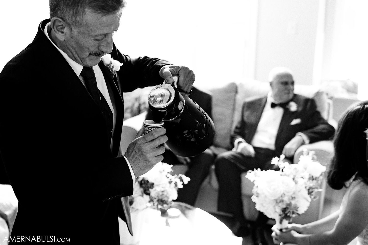Black and white candid moment during wedding ceremony preparations.