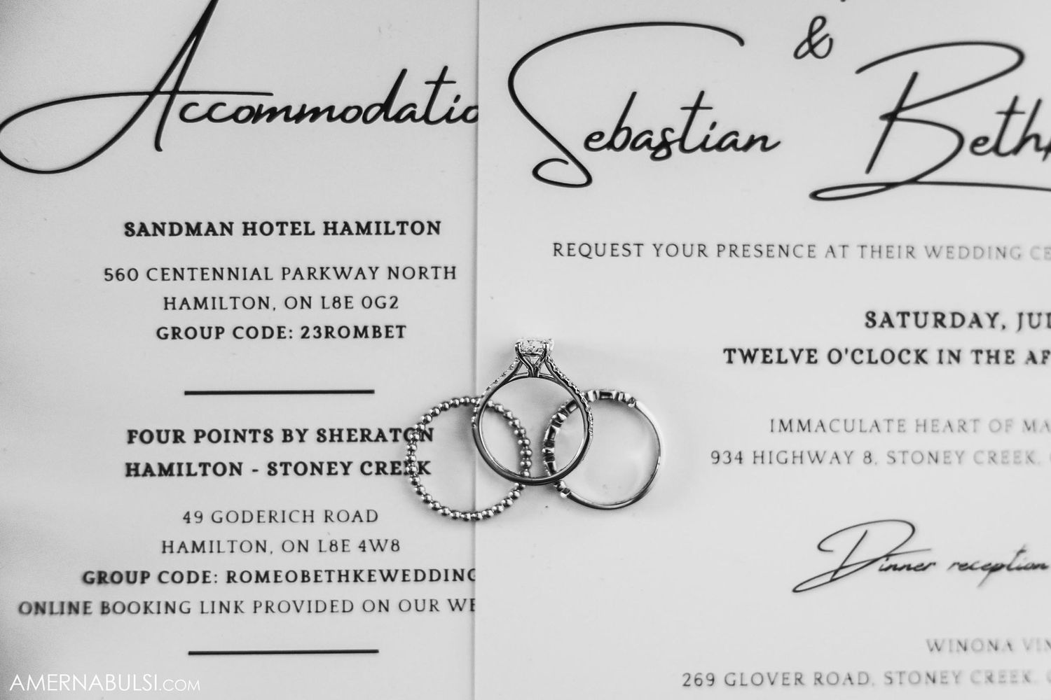 Black and white wedding invitation with elegant script font and interlinked rings design.