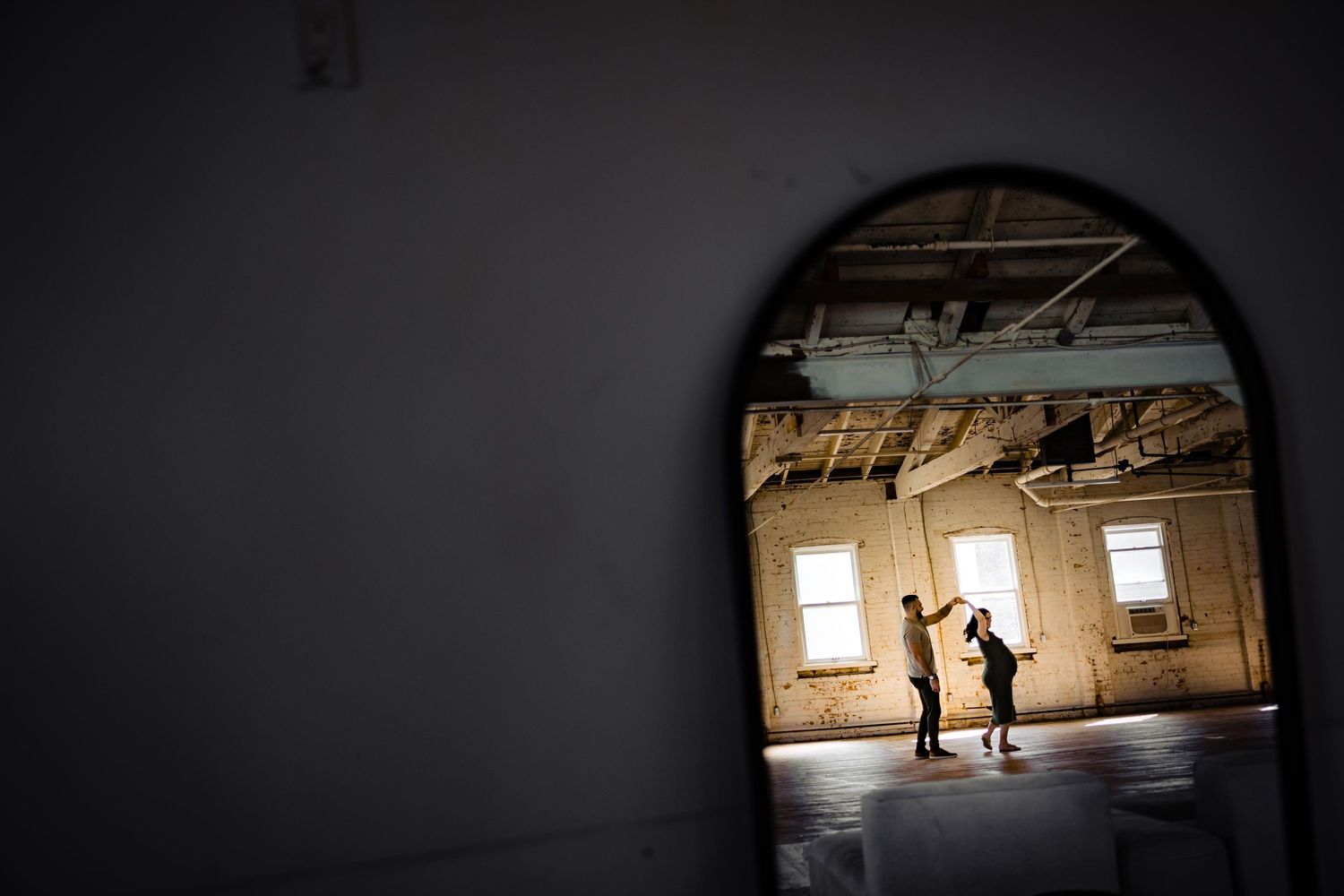 A silhouetted couple seen through an archway in an abandoned building.