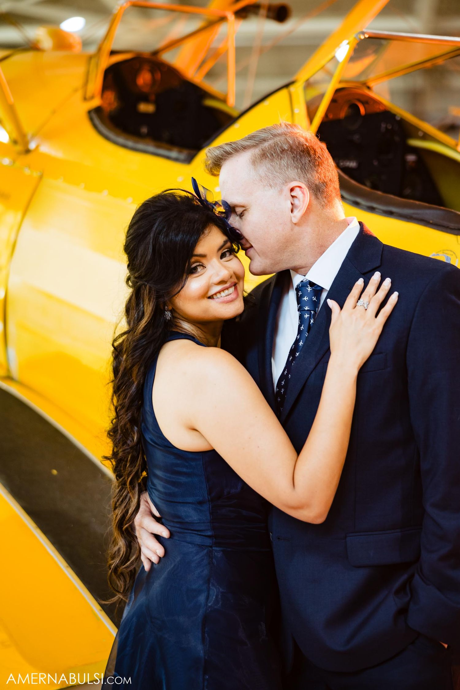 Romantic portrait against bright yellow vintage airplane.