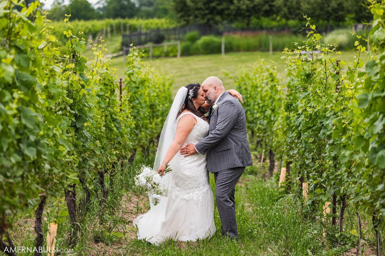 A romantic moment between newlyweds in a lush vineyard.