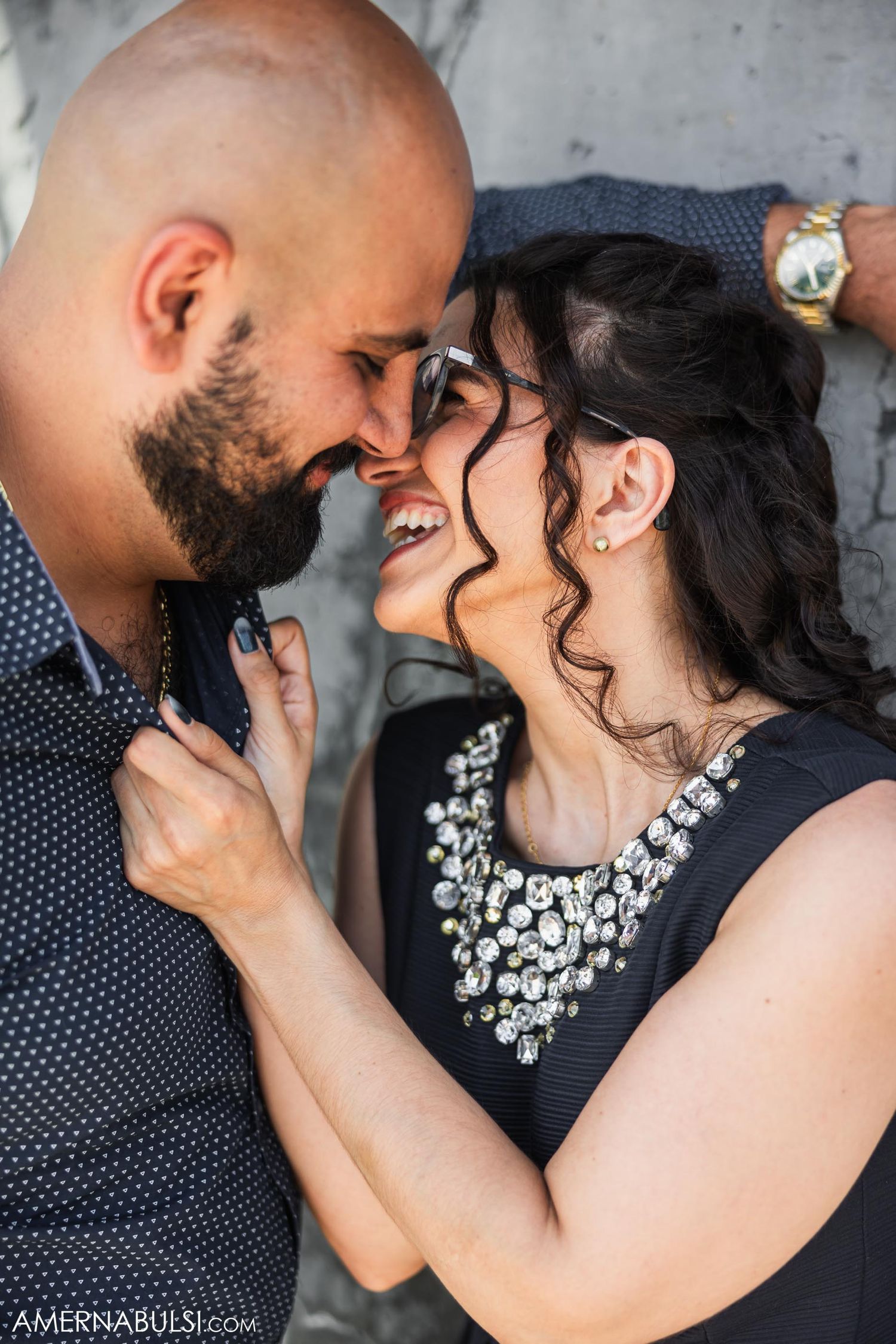 A couple shares an intimate close-up moment wearing formal attire.