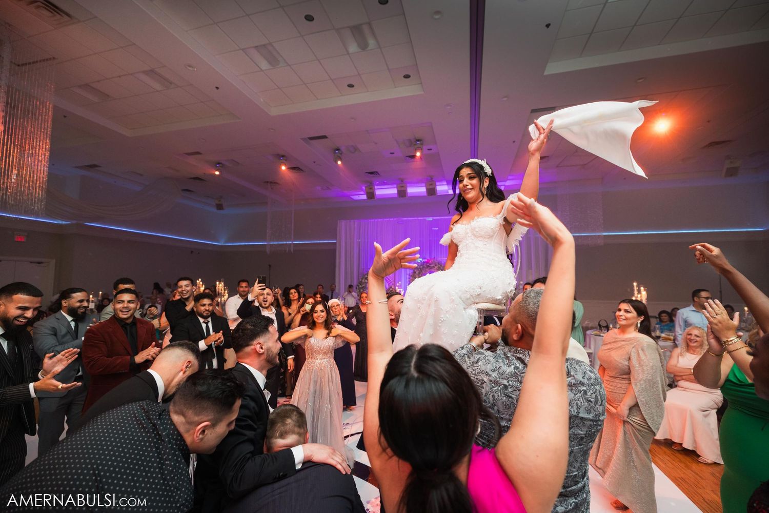 Wedding celebration with guest being lifted above crowd during dance party.