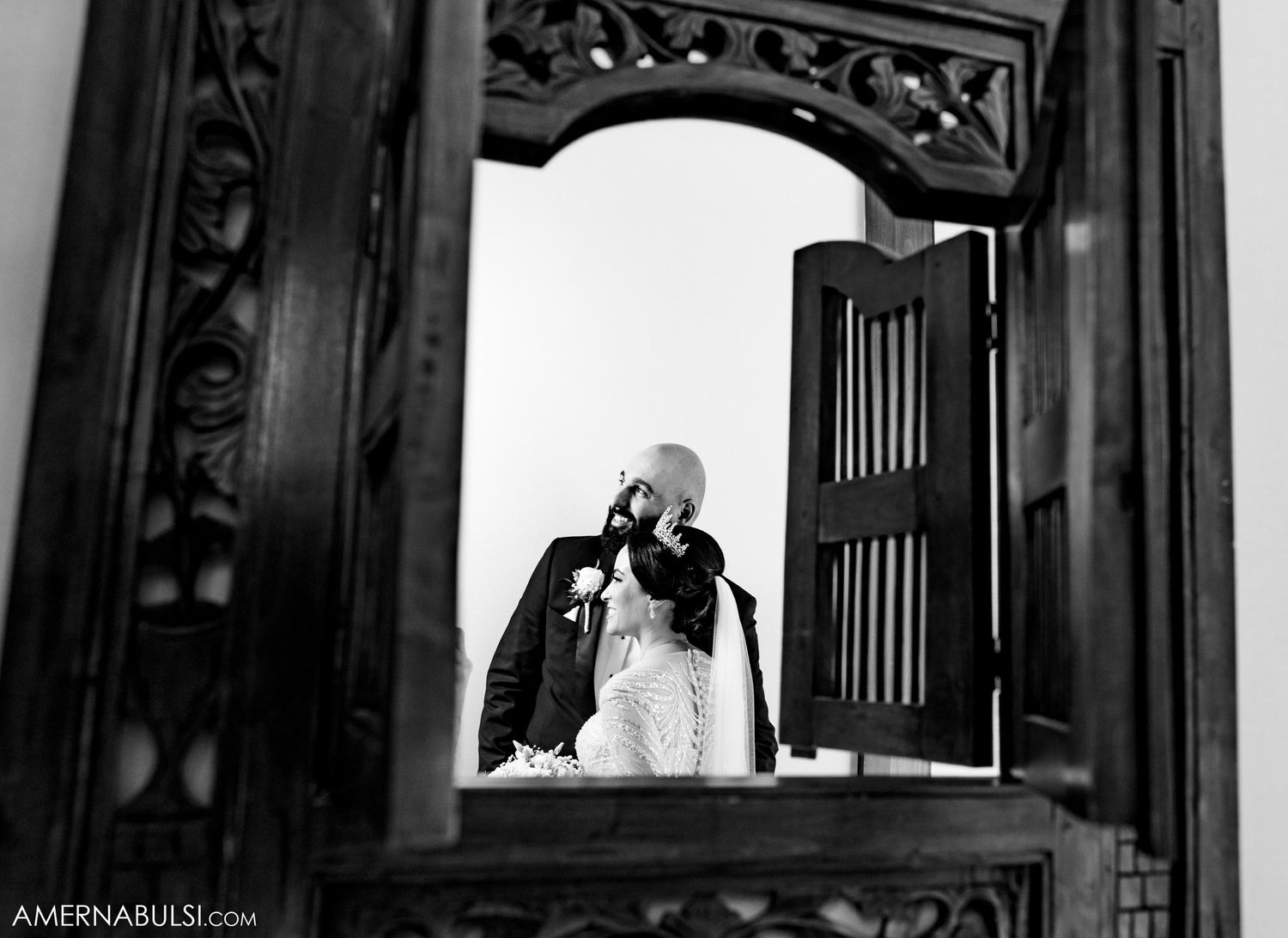 Wedding couple reflection in ornate mirror frame with dramatic lighting.