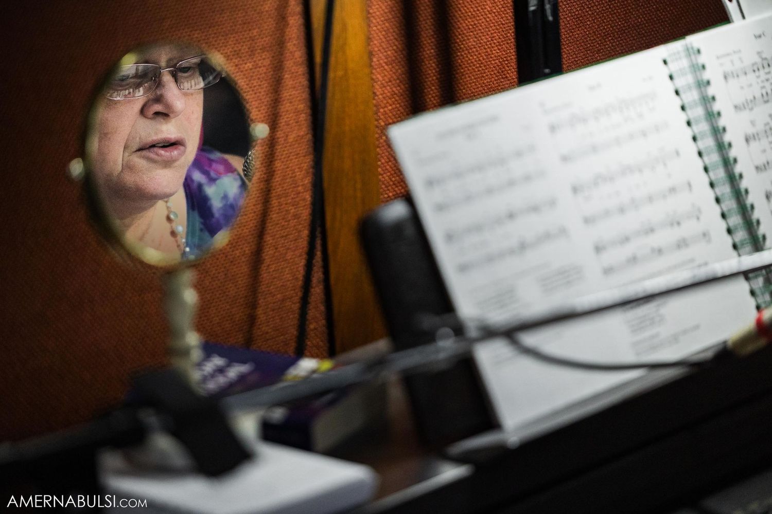 Artistic reflection shot of musician in mirror with sheet music stand.