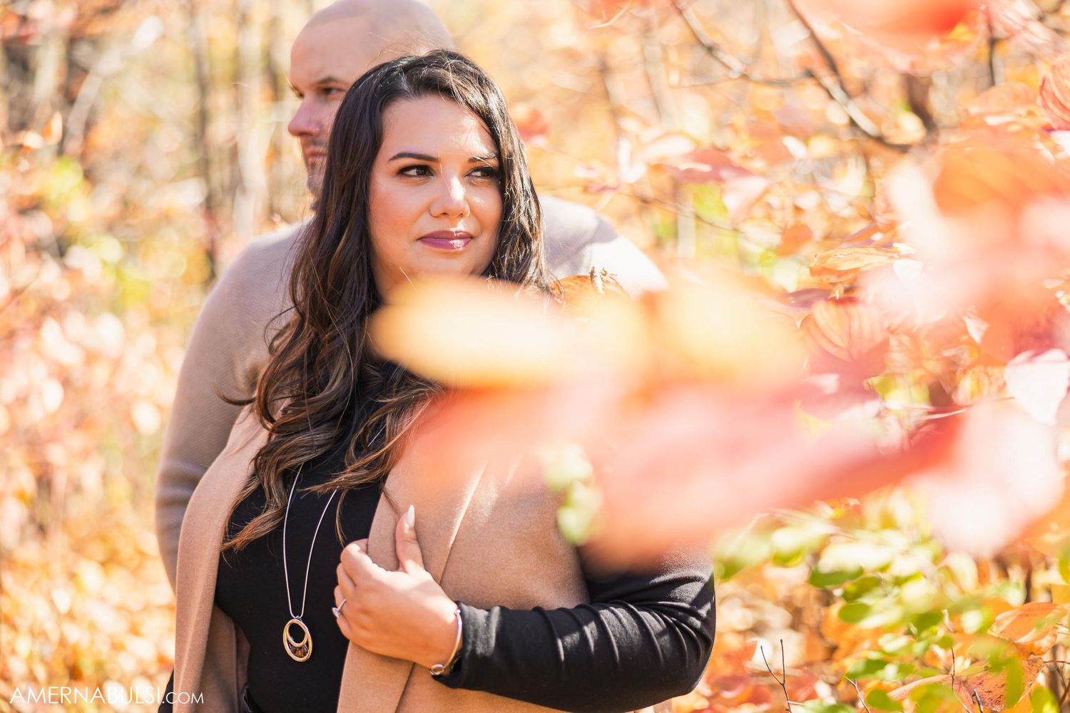 Close-up autumn portrait in warm tones showing through bokeh fall leaves.
