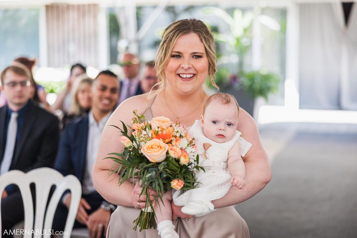 Wedding celebration moment with peach floral bouquet and white decorations.