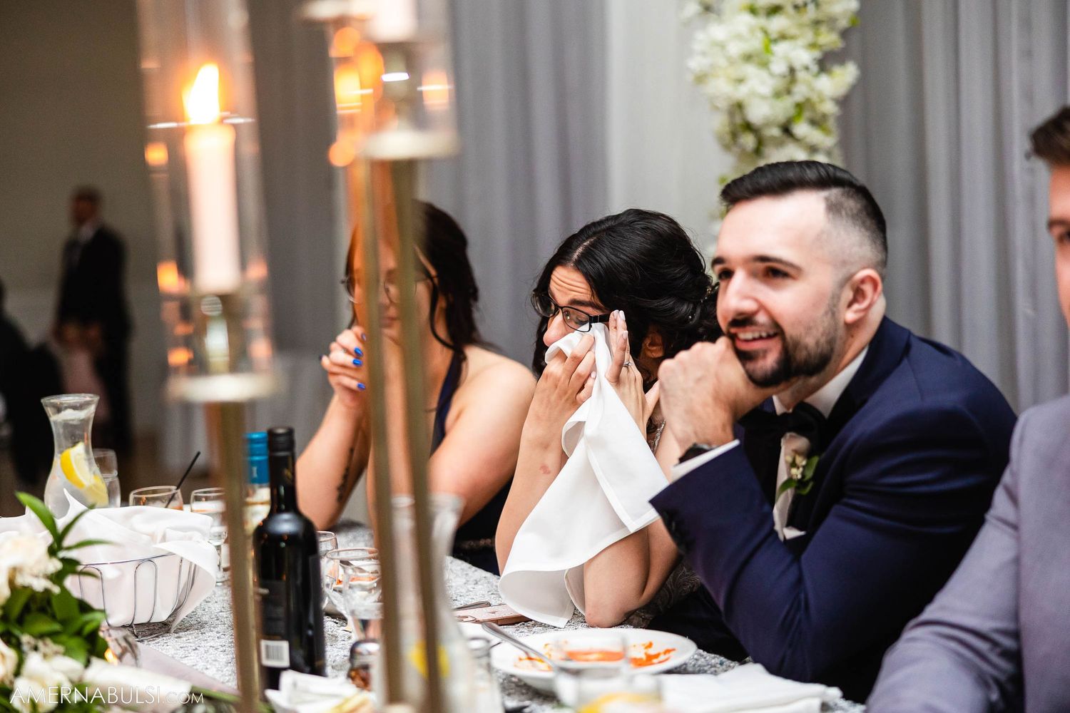 Wedding guests sharing emotional moments and laughter during reception speeches.