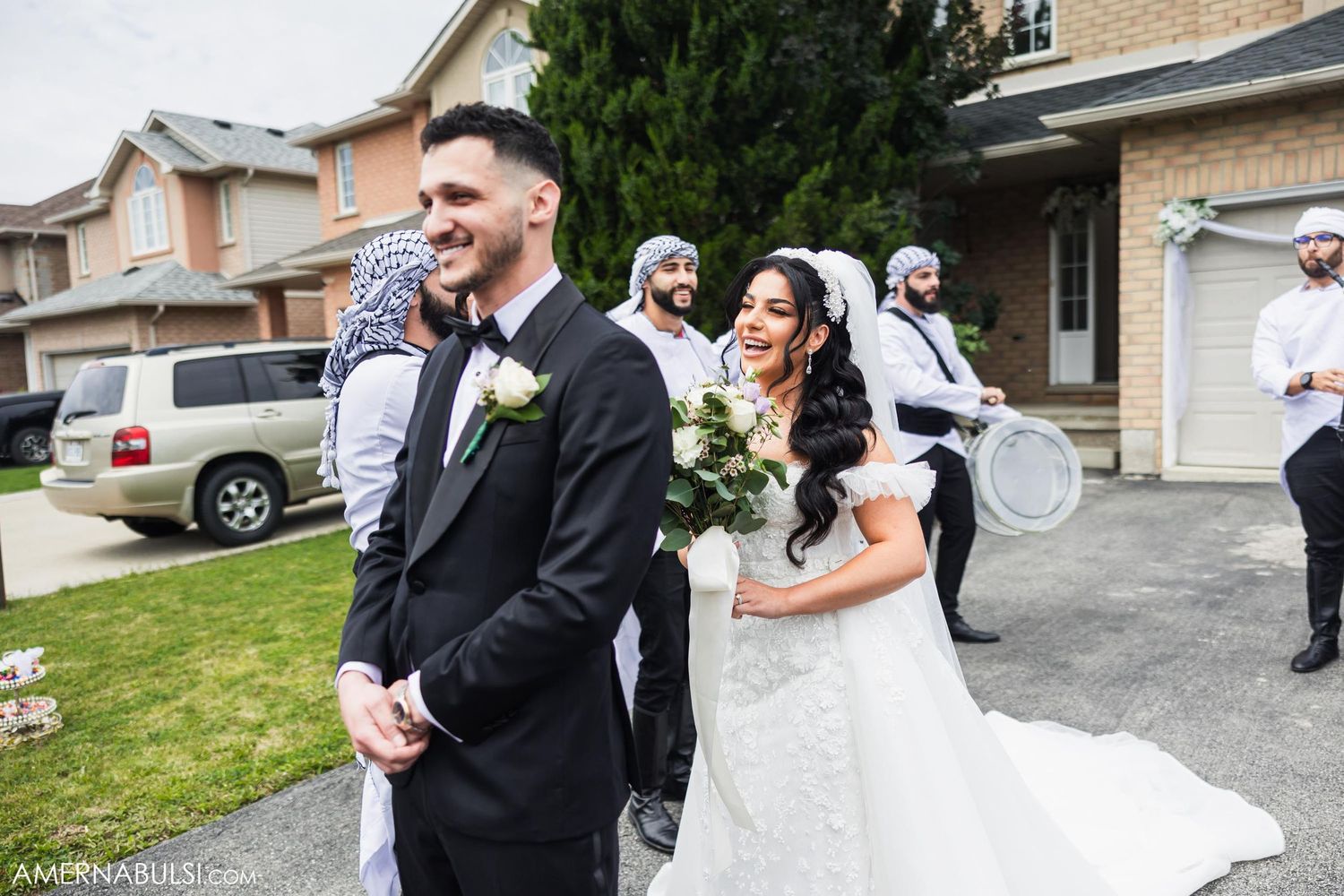 Wedding party members celebrate behind the bride and groom during their first look reveal.