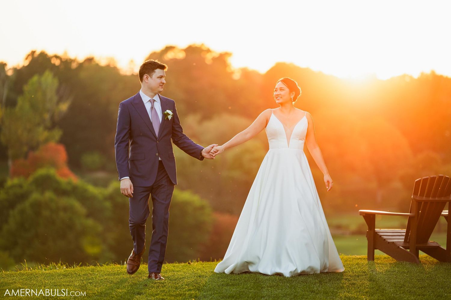 Couple shares joyful moment at sunset on wedding day with golden lighting.