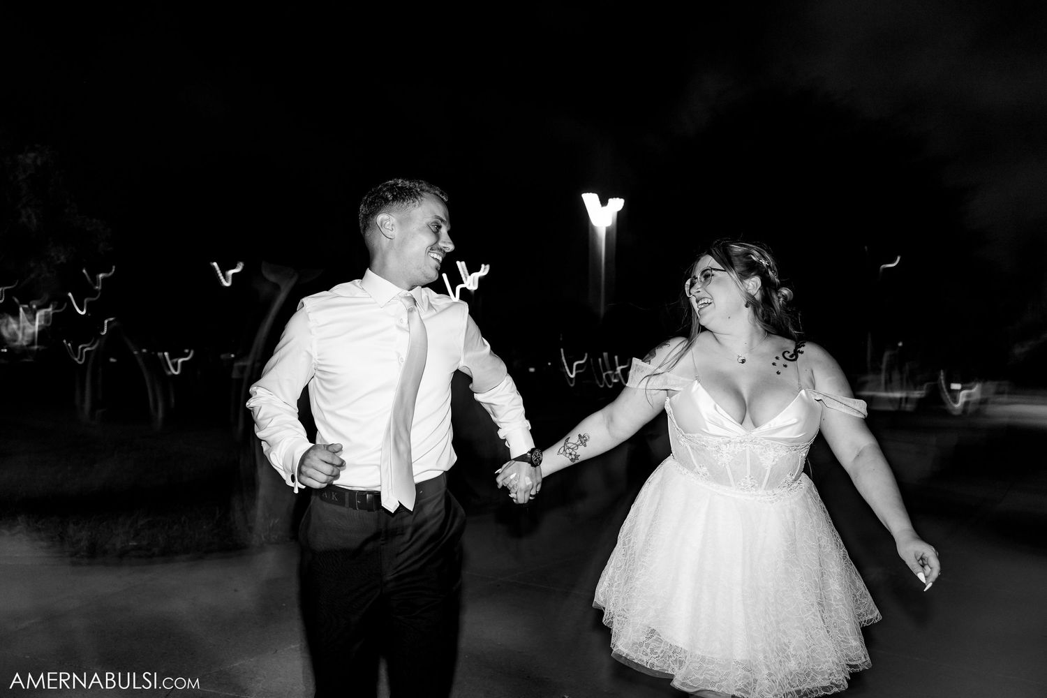 Wedding guests dancing joyfully together on the dance floor during an evening reception celebration.