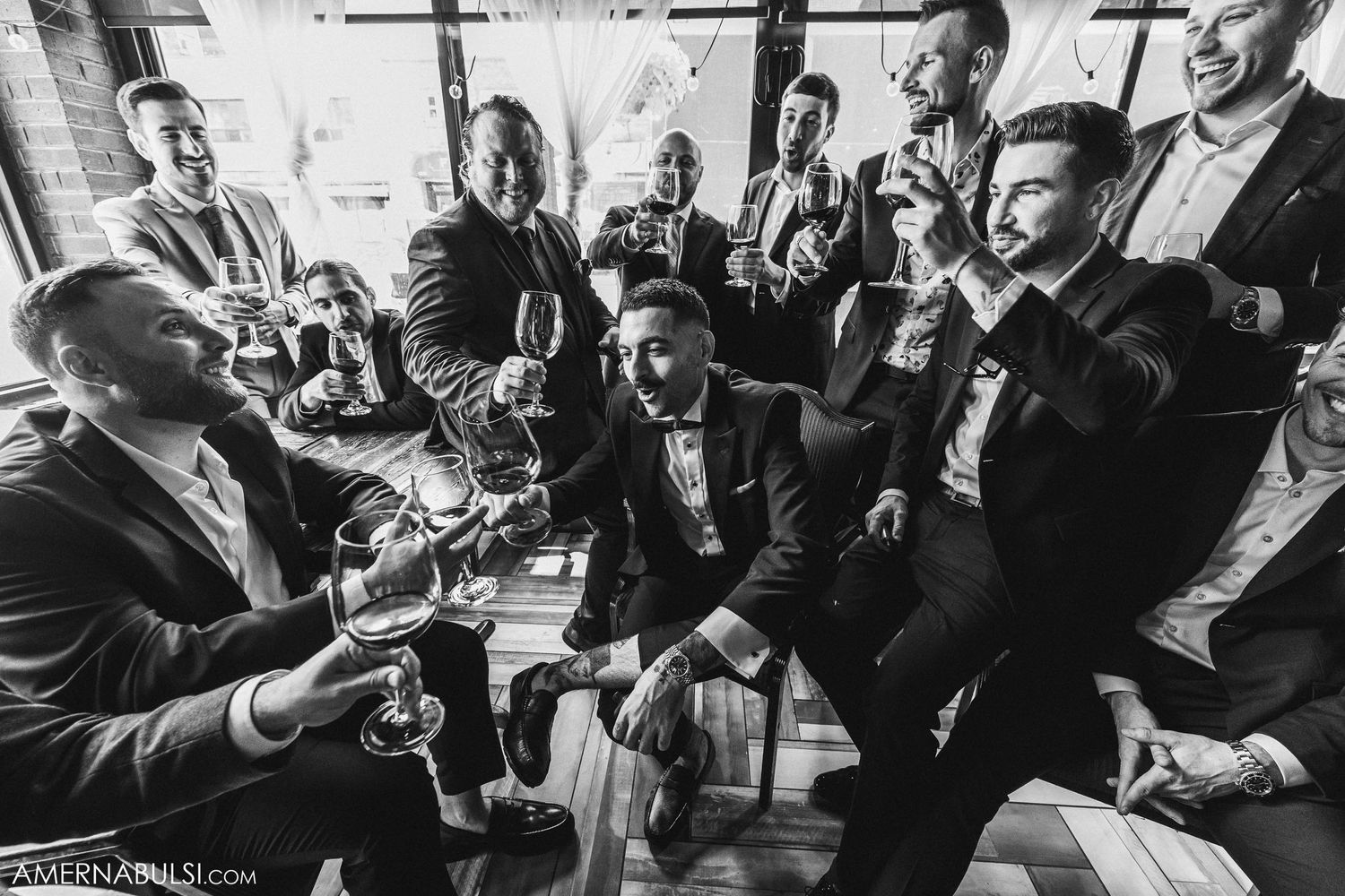 Black and white photo of a celebration in a room with people laughing and enjoying themselves.