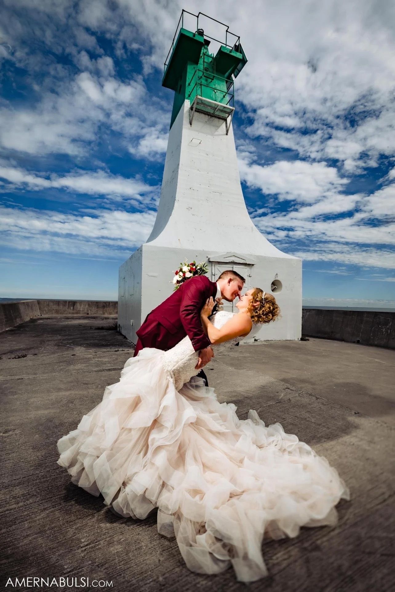 Dramatic wedding photo sequence at a lighthouse with flowing blush gown against blue sky.