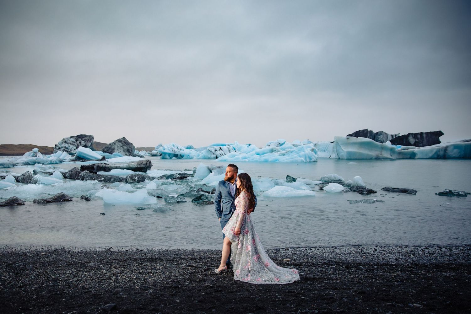 Dramatic wedding photos taken at a glacial lagoon with icebergs in the background.