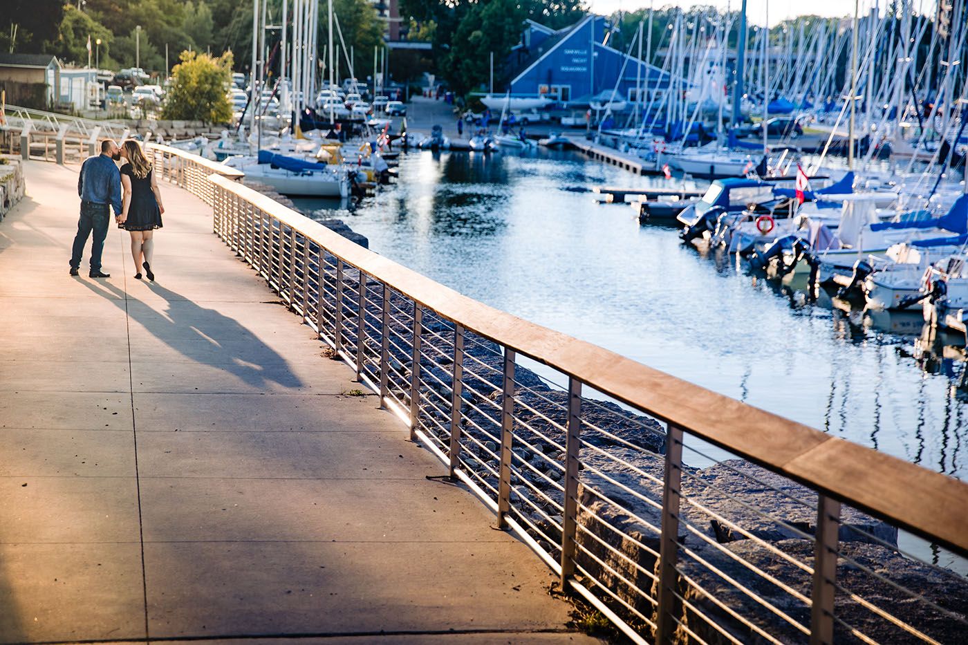 A scenic marina walkway with boats and docks visible in the background.
